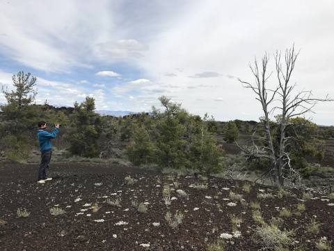 Field researcher photographing volcanic terrain at Craters of the Moon