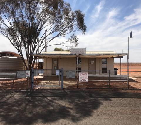 Remote outback airfield building beneath a broad desert sky