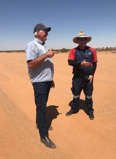 Two members of the Simpson Desert survey team standing on red sand