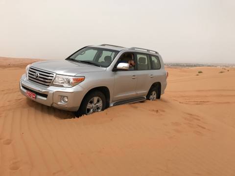 Four-wheel-drive vehicle paused in deep desert sand