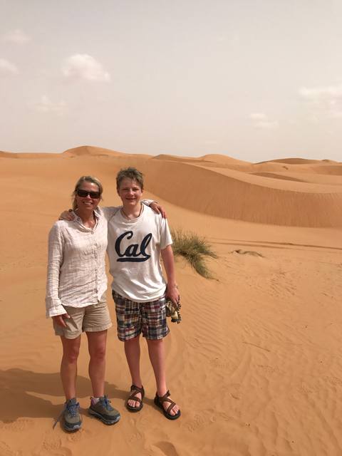 Lisa Wood and a companion standing together among orange dunes