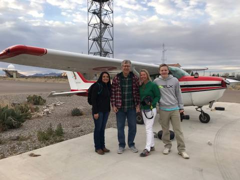 White Sands aerial survey team beside a red and white airplane