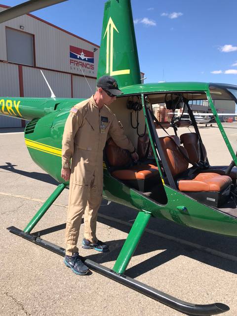 Pilot preparing to board a green survey helicopter