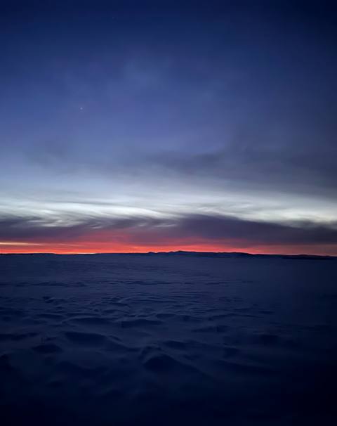 Red sunrise beneath storm clouds over the snowy Camas Prairie