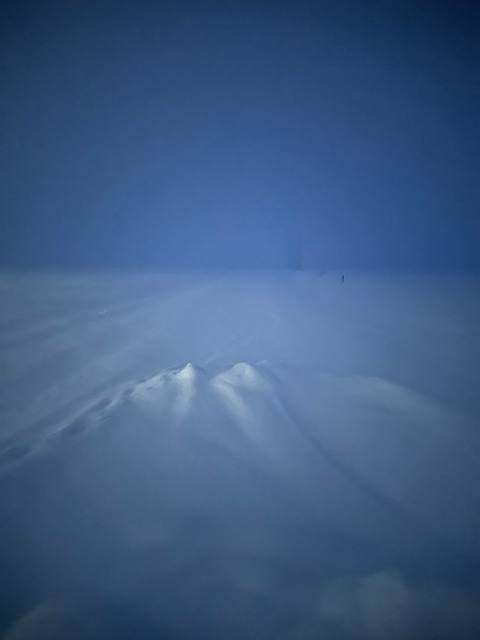 Wind-sculpted snowdrift in blue predawn light