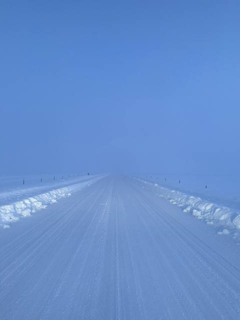 Road disappearing into a blue-white winter haze