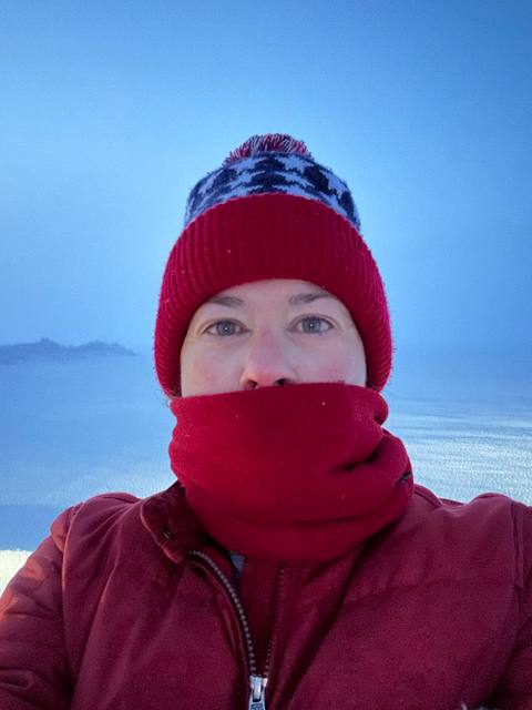 Lisa Wood in red winter gear on the snow-covered prairie