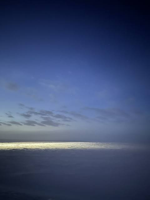 Snowfield beneath layered twilight clouds